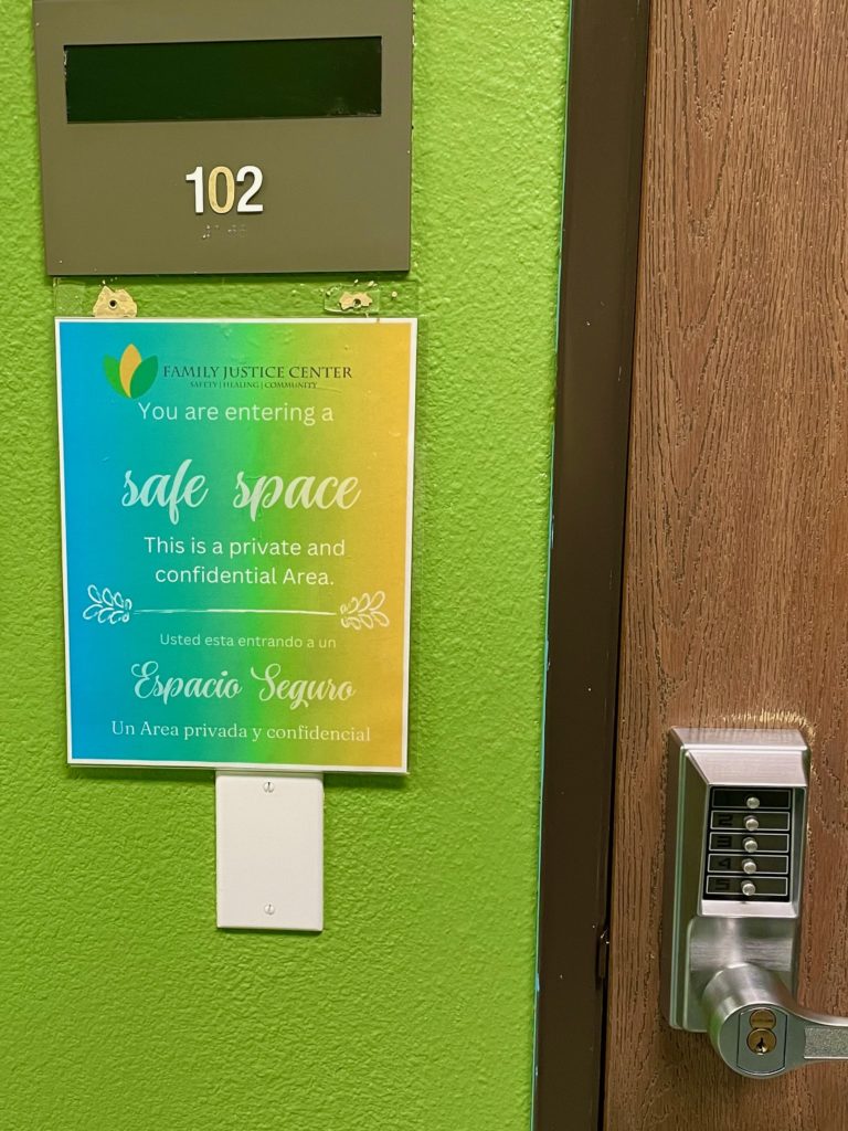 A printed "safe space" sign hangs outside a client meeting room